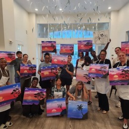 a group of people holding paintings